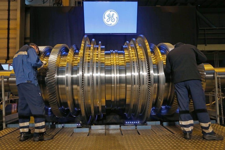 Employees work on a General Electric turbine.